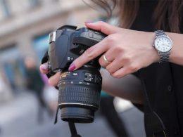 mujer ajustando cámara de fotos