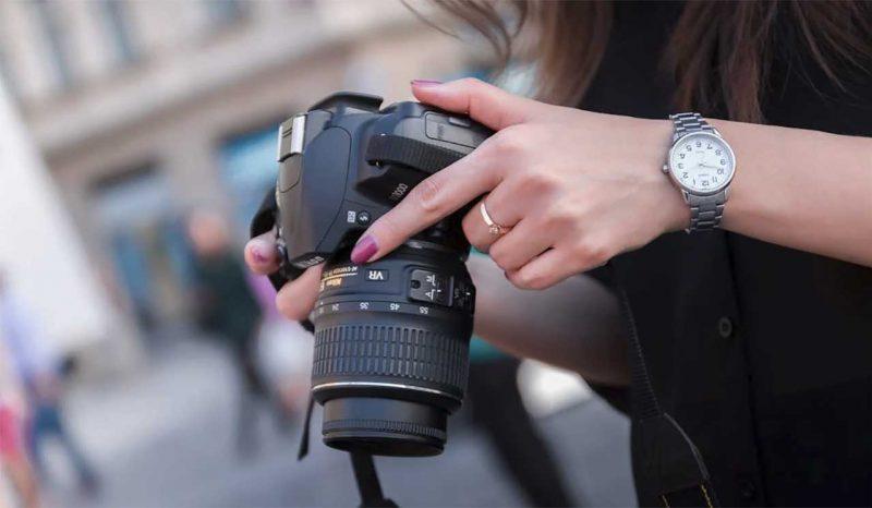 mujer ajustando cámara de fotos