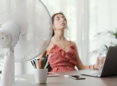 Mujer sentada en el escritorio de casa y trabajando con una computadora,