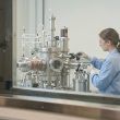 Científica trabajando con maquinaria de alta precisión en un laboratorio de investigación