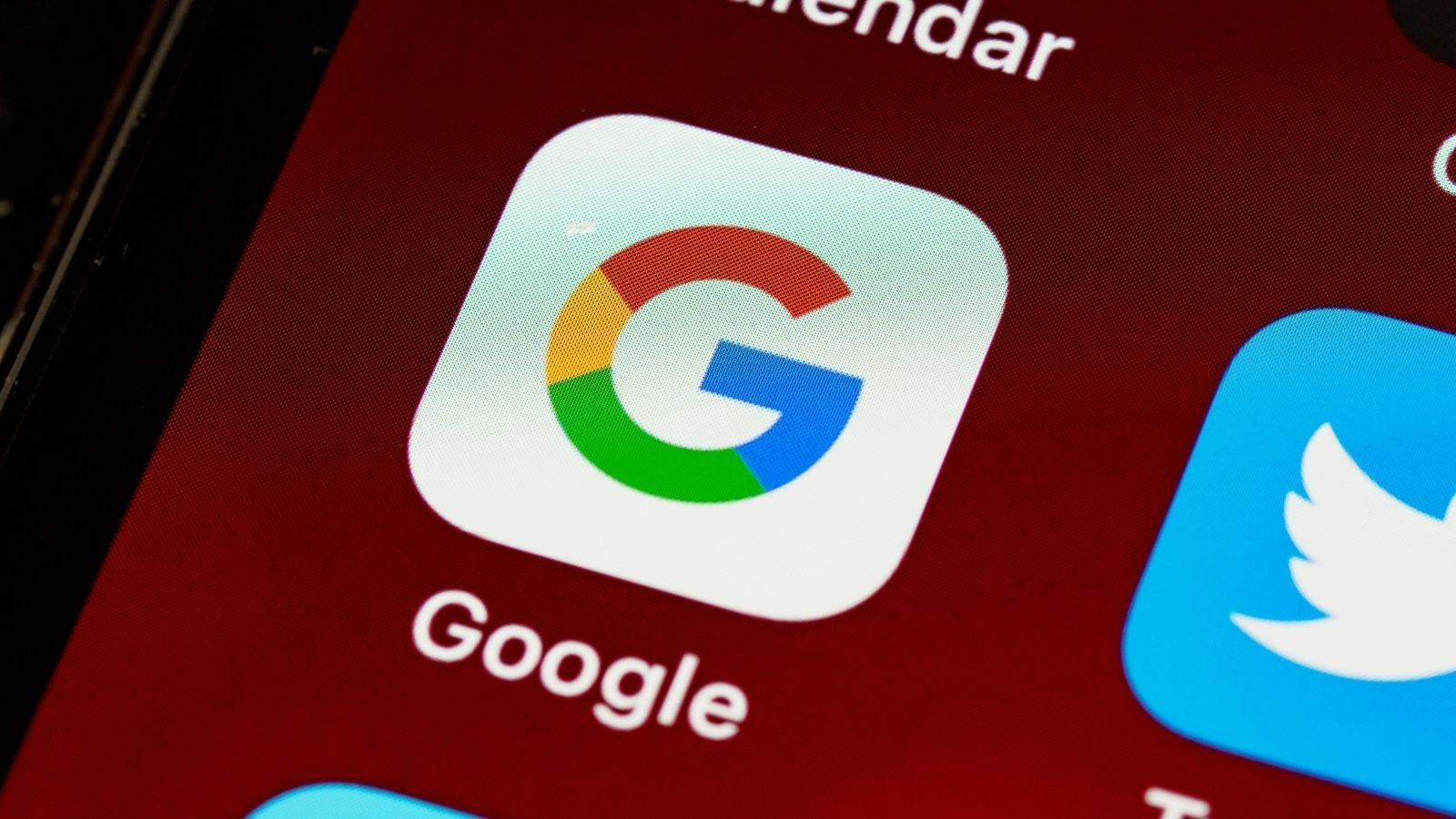 Primer plano de la aplicación de búsqueda de Google instalada en un teléfono móvil junto a otros iconos de redes sociales.