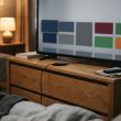 Televisor inteligente sobre un mueble de madera en un dormitorio con la interfaz de aplicaciones en pantalla.