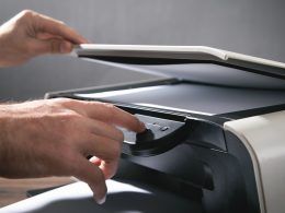 Hombre copiando y escaneando documentos en la oficina.