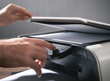 Hombre copiando y escaneando documentos en la oficina.