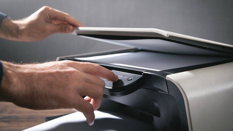 Hombre copiando y escaneando documentos en la oficina.